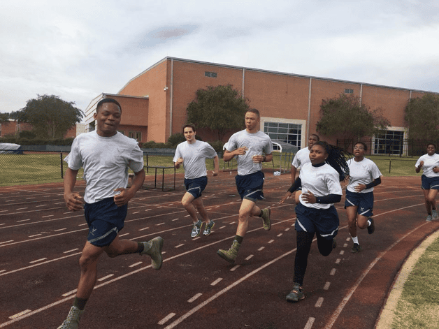 Cadets running together on a track during unit physical training