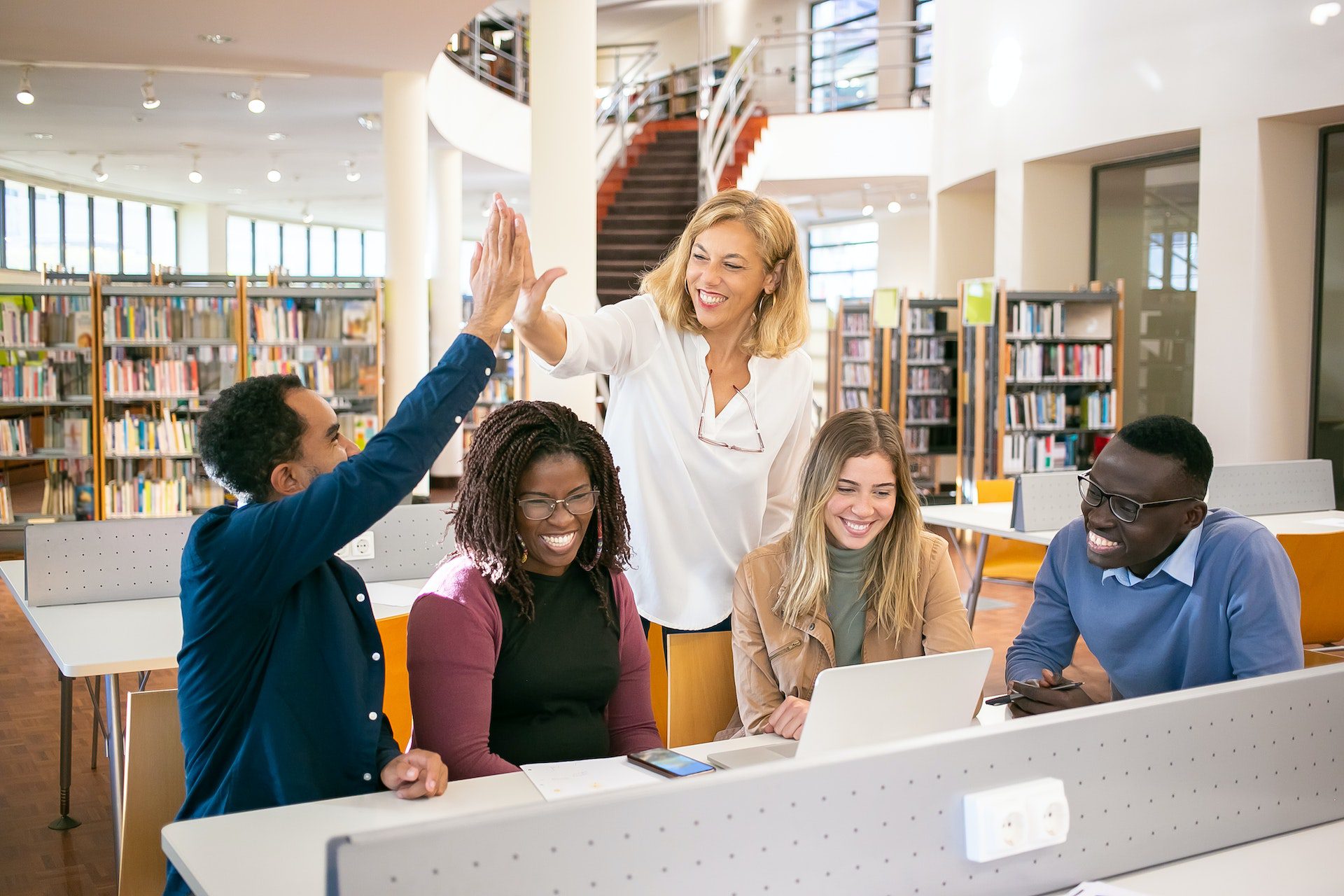 instructor high-fives student, other students smile