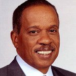 Headshot of a smiling man in a suit and tie.